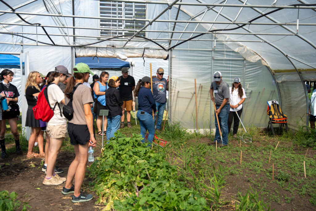 Figure 8. The Purdue Student Farm hosts the annual Small Farm Education Field Day annually during the third week of July. Here Stephen Meyers and graduate student Celia Corado demonstrates different hand weeding tools to attendees (Photo by Joshua Clark).