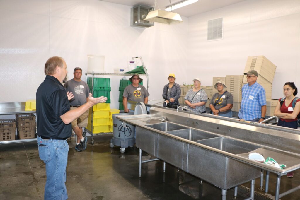 Scott Monroe, Food Safety Educator, Purdue Extension, training growers in the wash pack at the Purdue Student Farm.