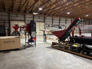 Sean with newly delivered garlic popping and peeling machinery (March 2026). 