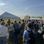 Attendees at the Fruit and Vegetable field day listen to Sydney Territo and Tucker LaRue talk about pollination and pest management in high tunnel tomato.