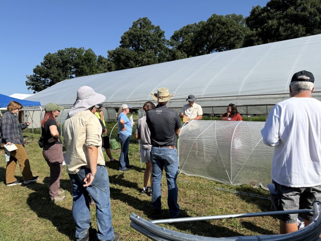 Small Farm Education field day attendees listen to Petrus Langenhoven talking about the benefits and construction of low tunnels.